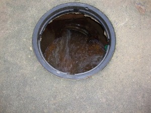 Neighborhood storm water catchment basin with missing man-hole cover, probably washed away during high flow.